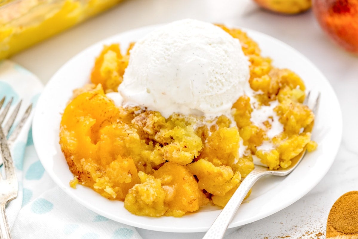 3 Ingredient Recipes - Peach cobbler with cake mix with a scoop of vanilla ice cream on top.