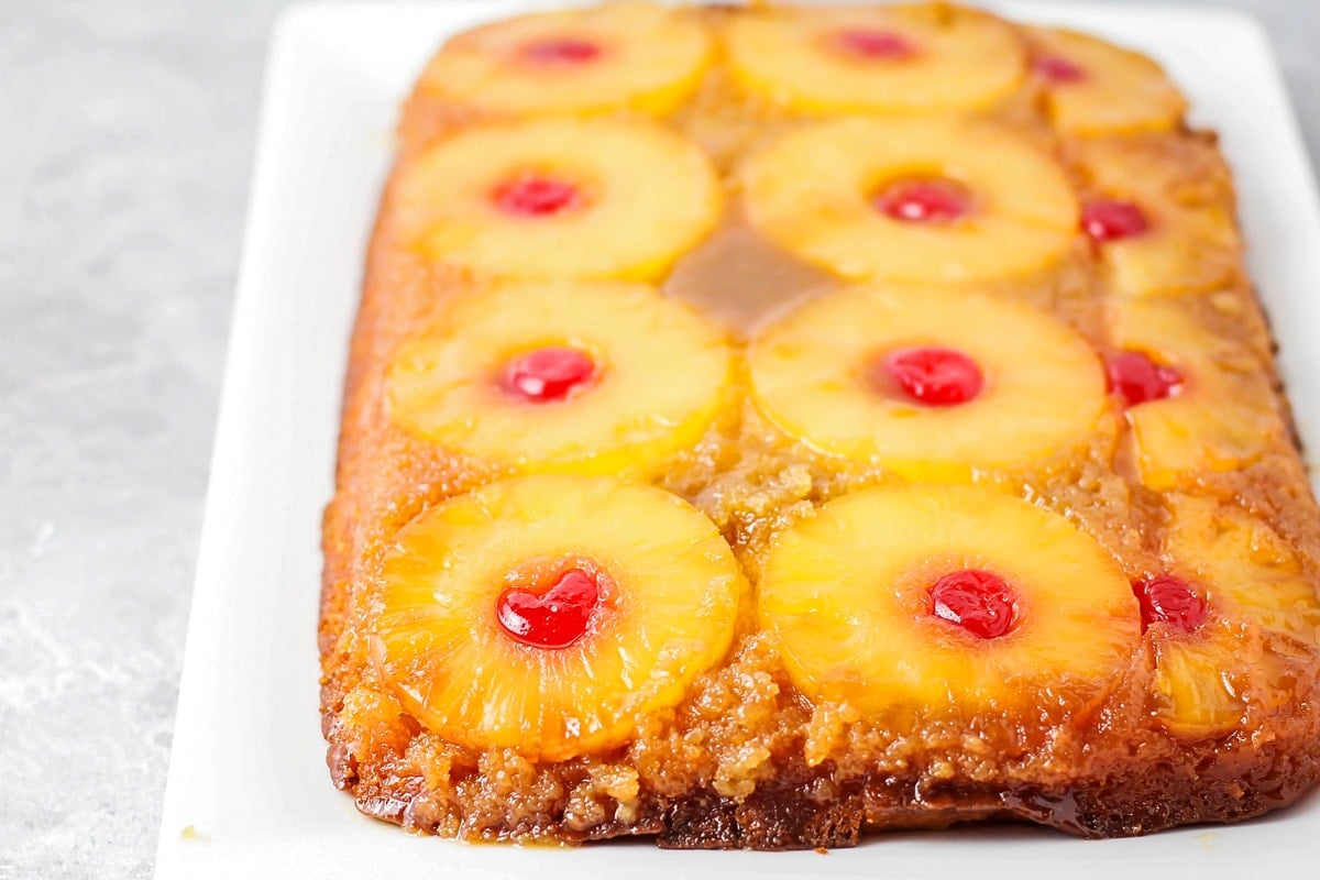 Pineapple upside down cake on white plate.