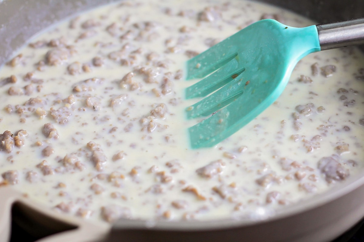 Making sausage gravy in a skillet.