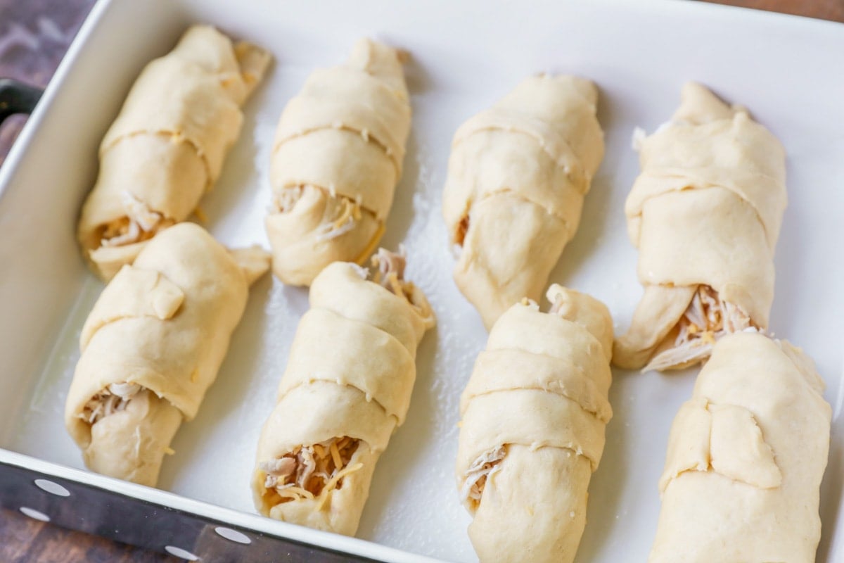 Crescent rolls wrapped with chicken and cheese for chicken crescent roll casserole.