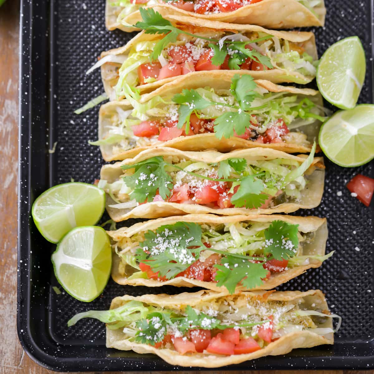 Six Chicken Tacos lined up on a plate.