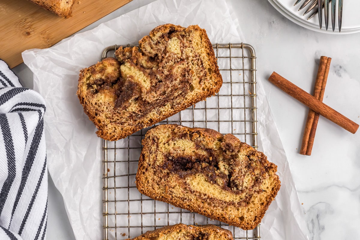 Two slices of cinnamon quick bread on a cooling rack.