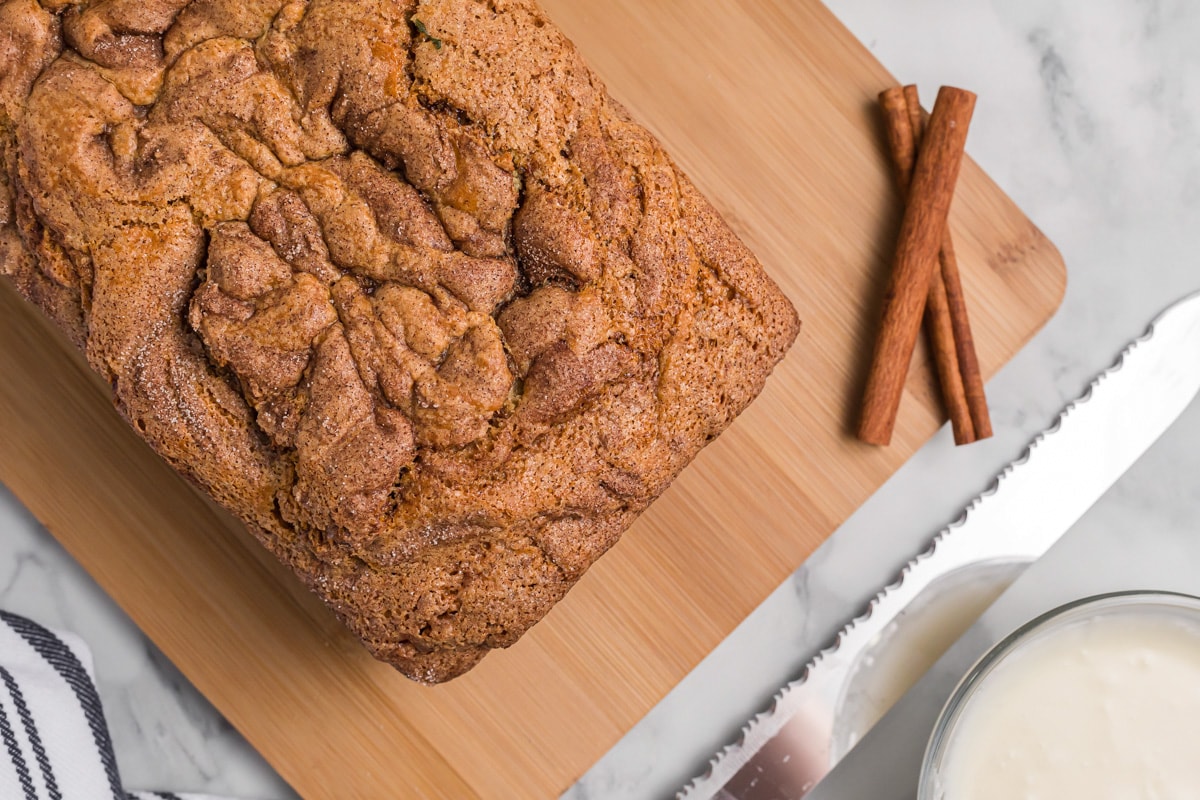 Freshly baked cinnamon quick bread on a cutting board.