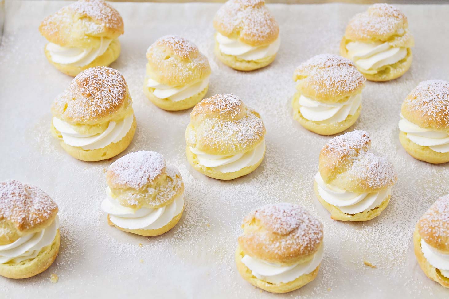 Homemade cream puffs recipe sprinkled with powdered sugar.