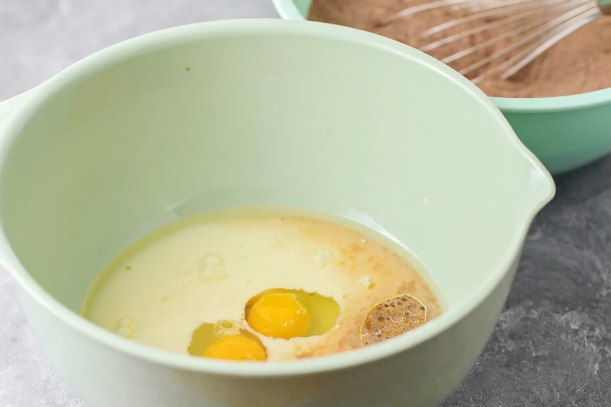 Wet ingredients for cake batter in a green bowl.
