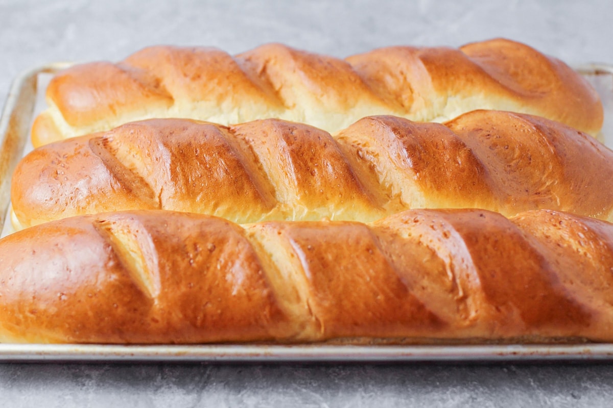 Loaves of french bread on a baking sheet.