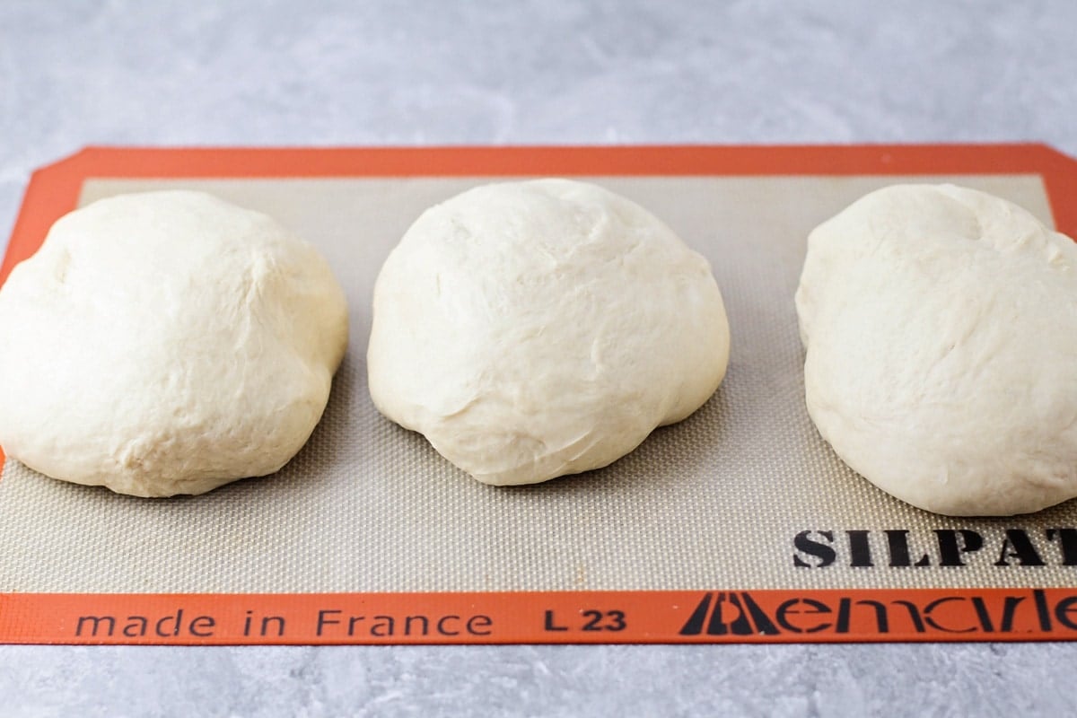 French Bread dough divided into three balls to make three loaves.