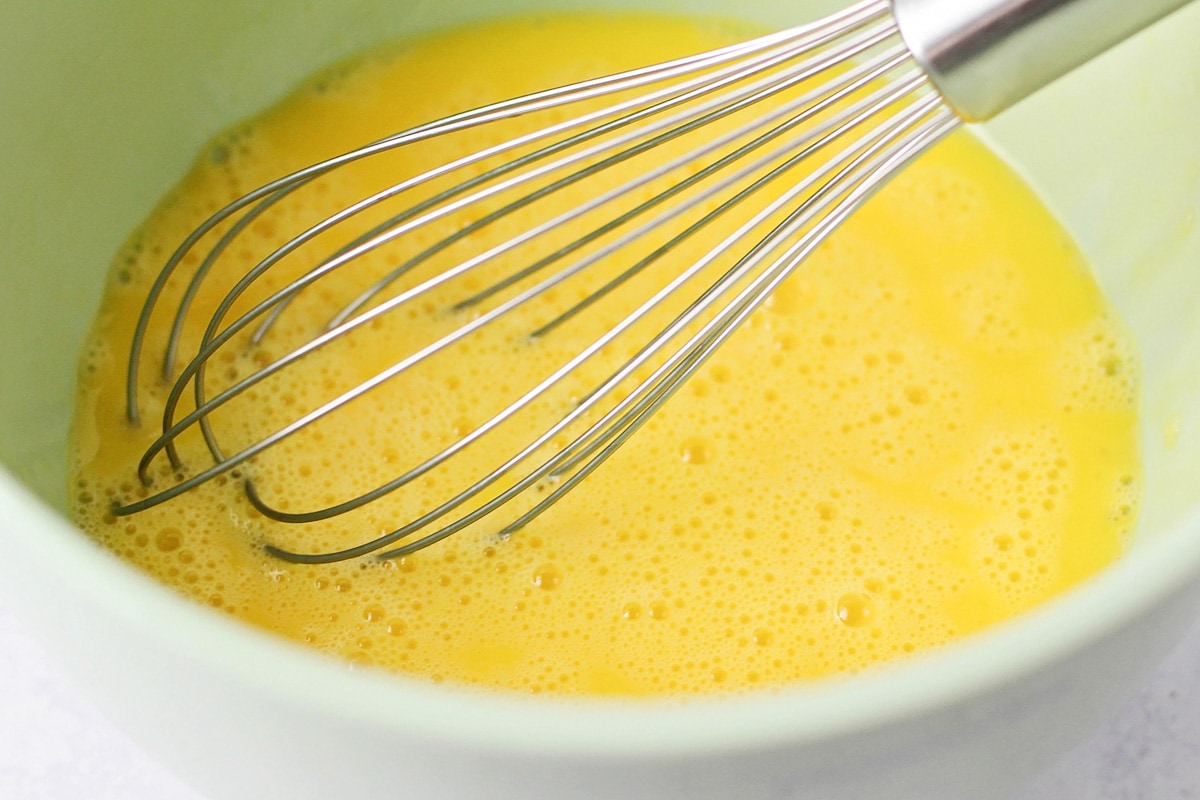 Mixing German pancake batter in a mint bowl.