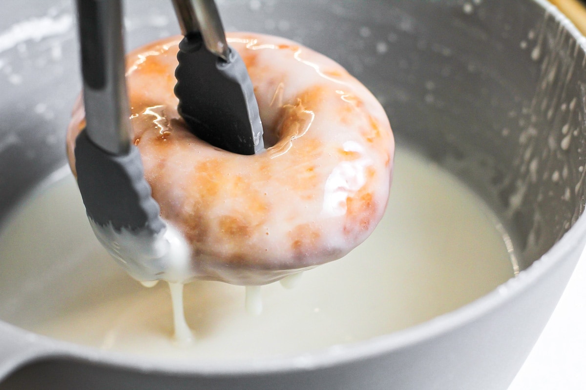 Freshly dipped homemade donuts in glaze.