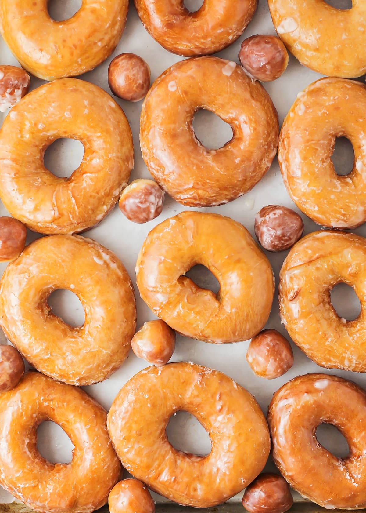 Close up of a tray filled with freshly glazed homemade donuts.