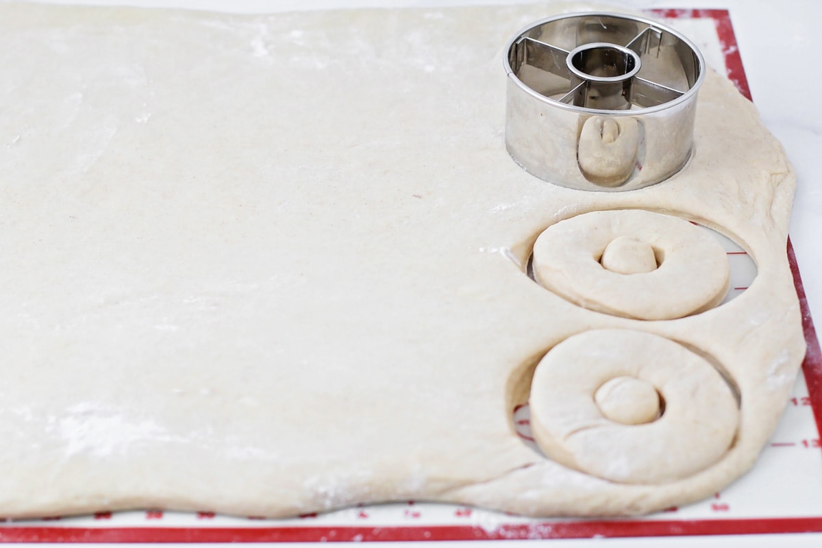 Cutting out homemade donuts form rolled dough.