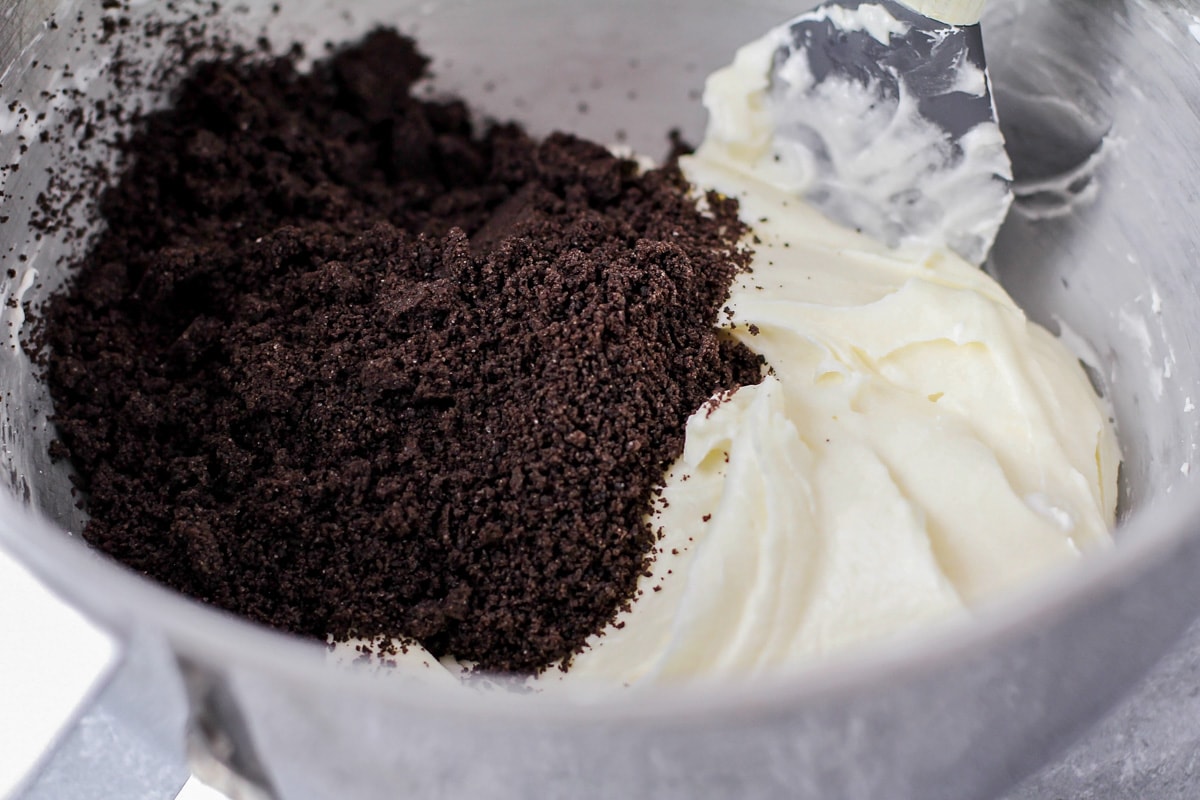 Mixing frosting and oreo crumbs for oreo buttercream frosting.