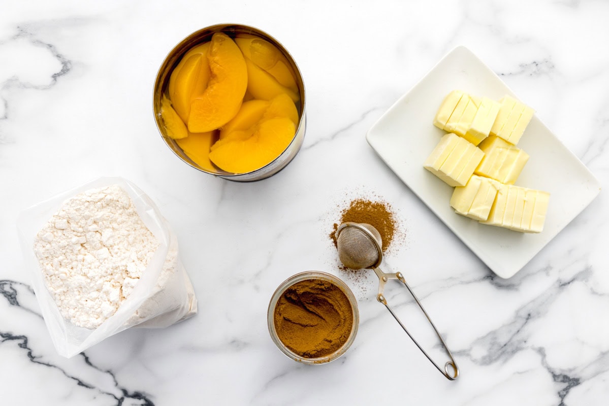 Ingredients for peach cobbler with cake mix on counter.