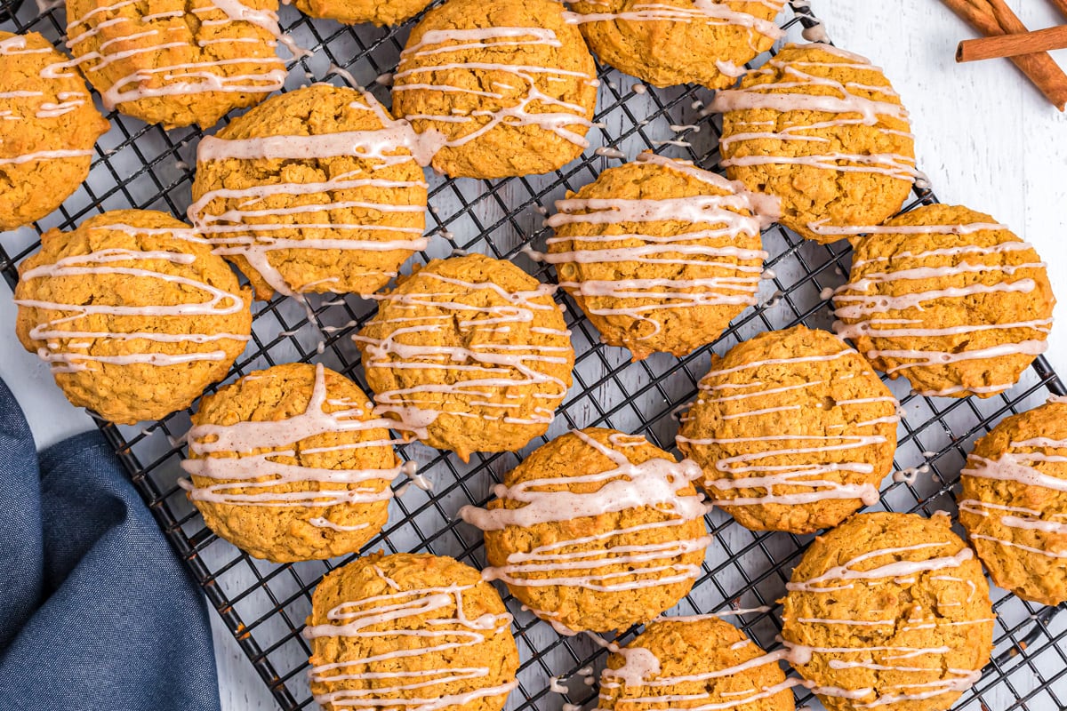 Cooling rack covered with pumpkin oatmeal cookies drizzled with glaze.