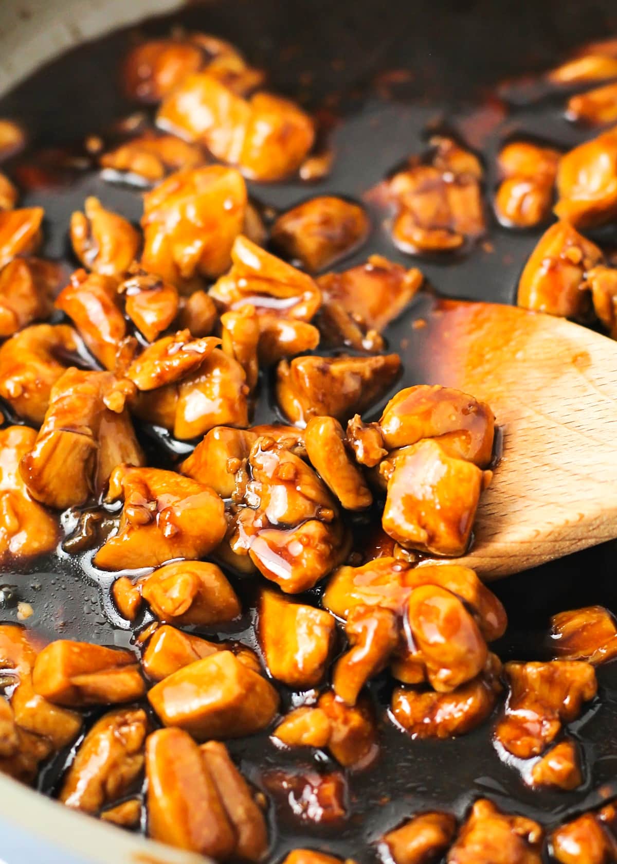 Cooking chicken in sauce in a skillet.