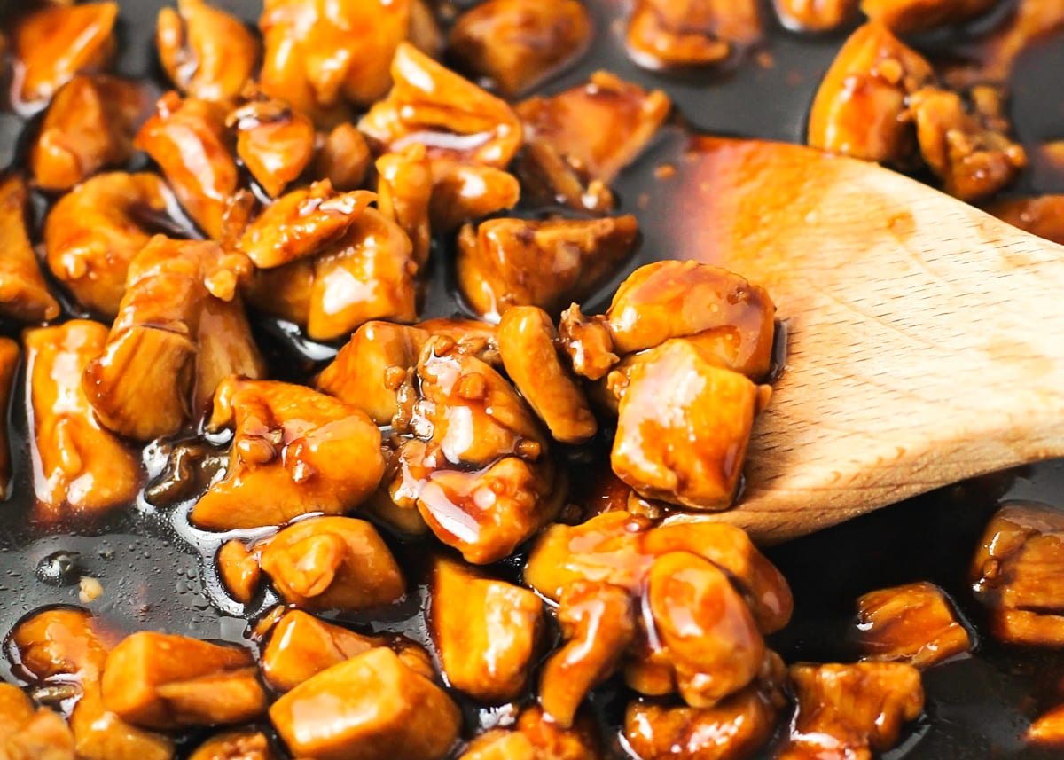 Teriyaki sauce coating chicken in a sauce pan.