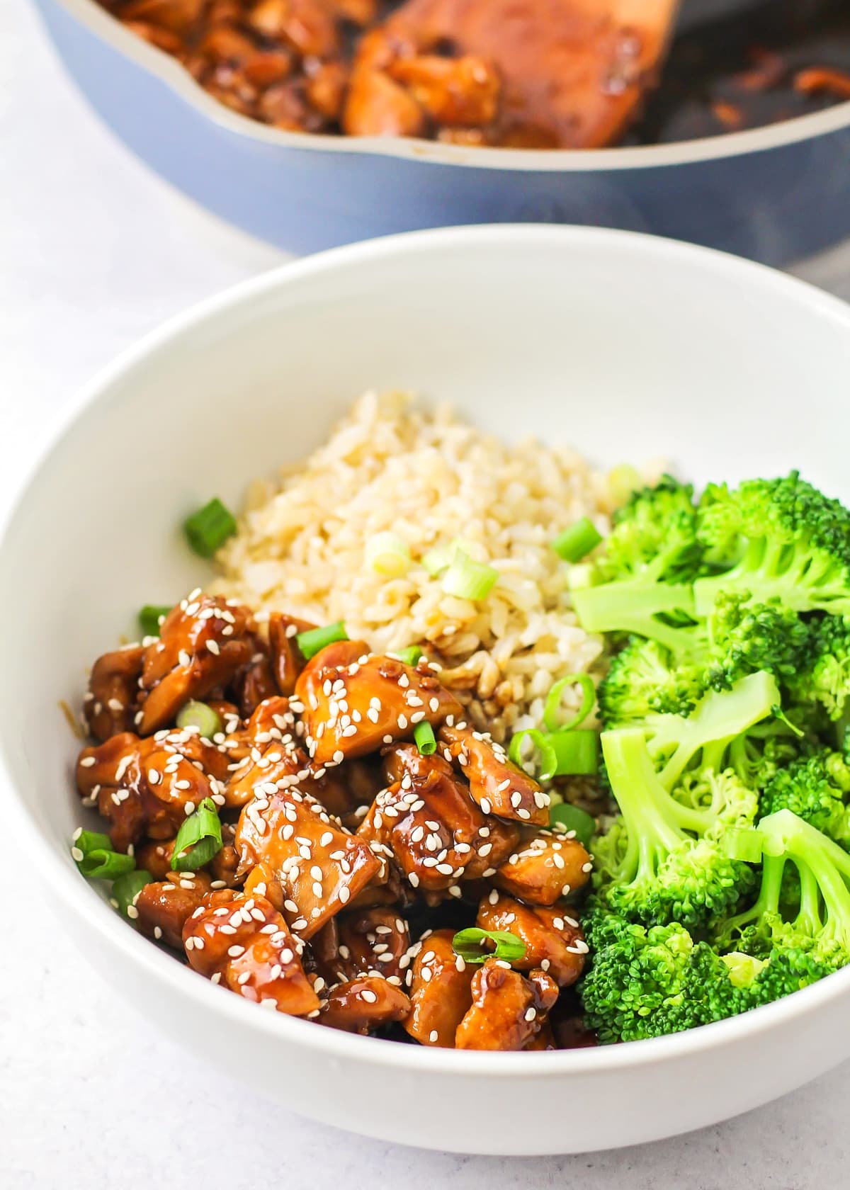 White bowl filled with teriyaki chicken, rice, and broccoli.