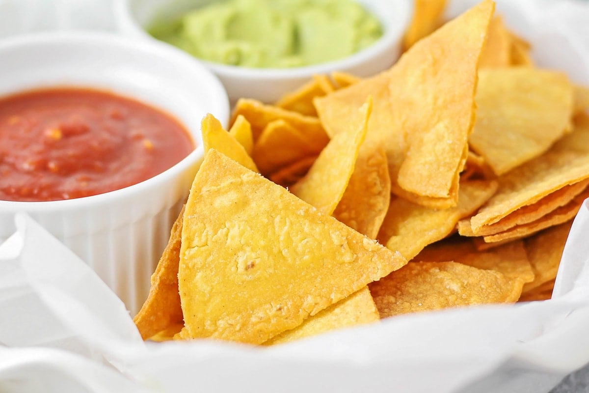 Homemade tortilla chips served with a side of guacamole.