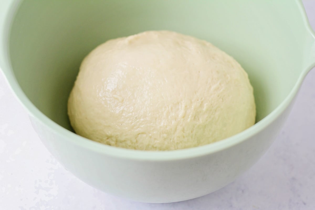 Dough for homemade beignets placed in bowl.