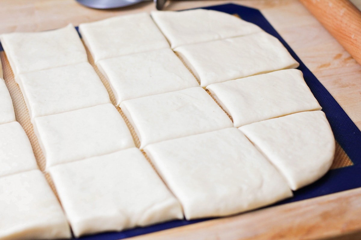 Beignet dough rolled out and cut into squares.