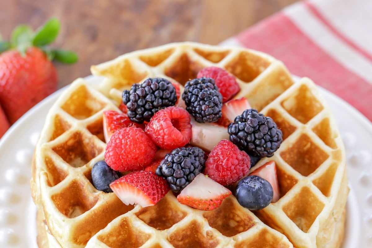 Two stacked Belgian waffles topped with fresh berries.