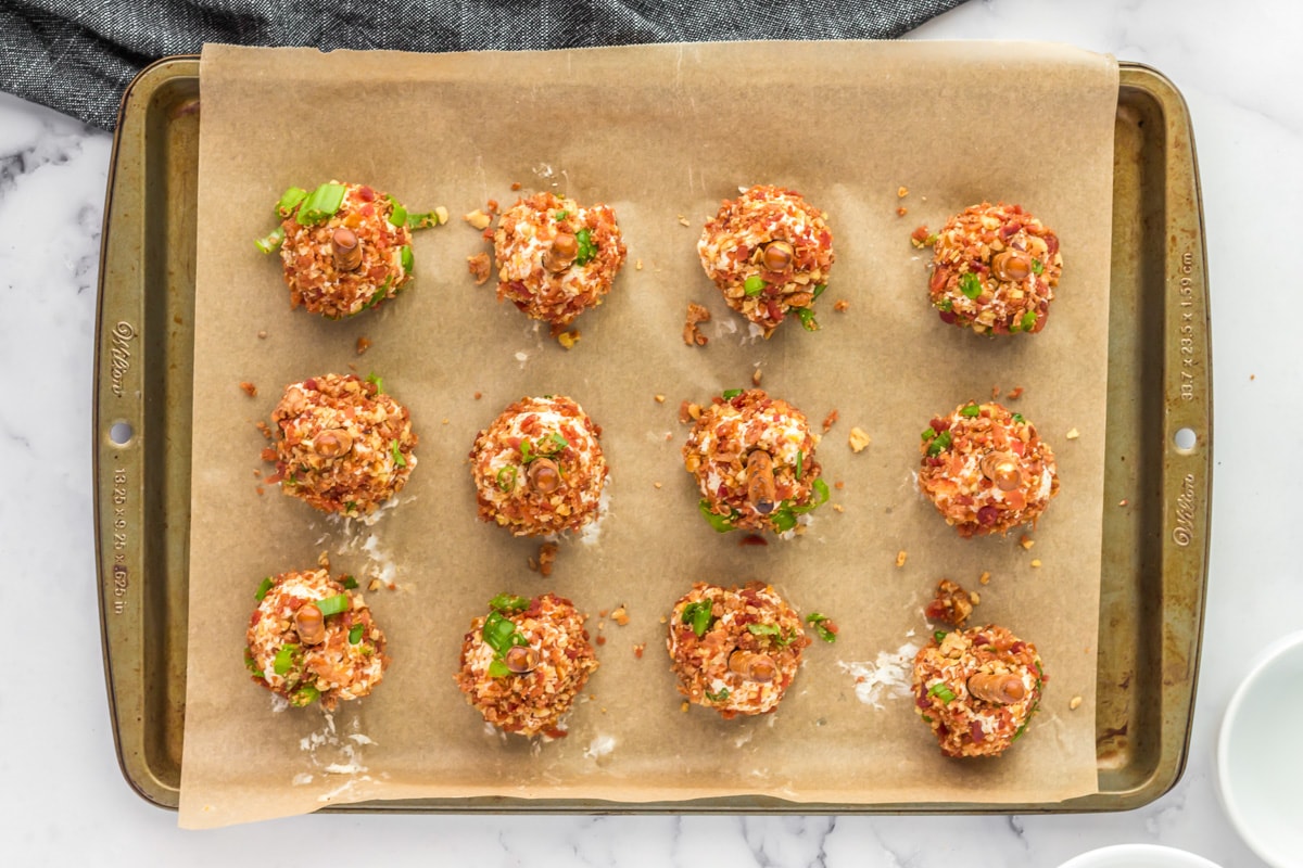 Bacon coated cheese ball bites on a baking sheet.