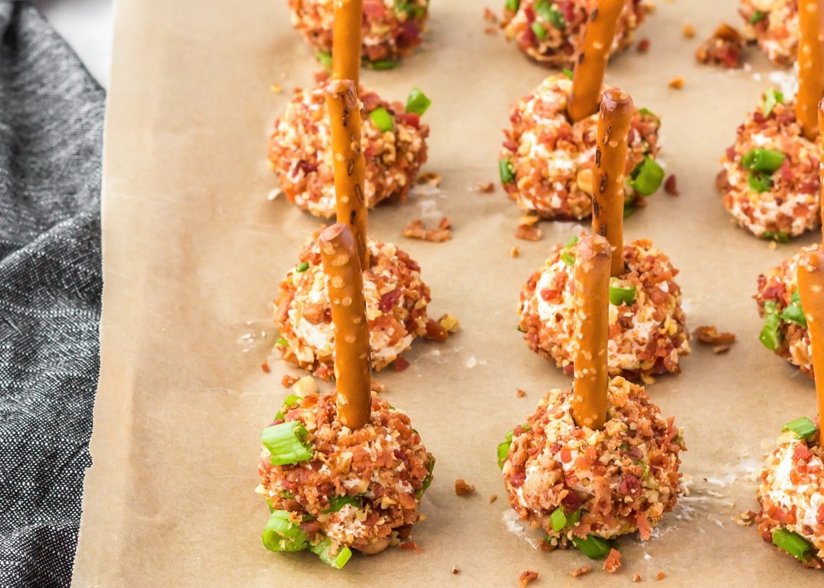 Loaded bacon cheese ball bites stuck with pretzel sticks.