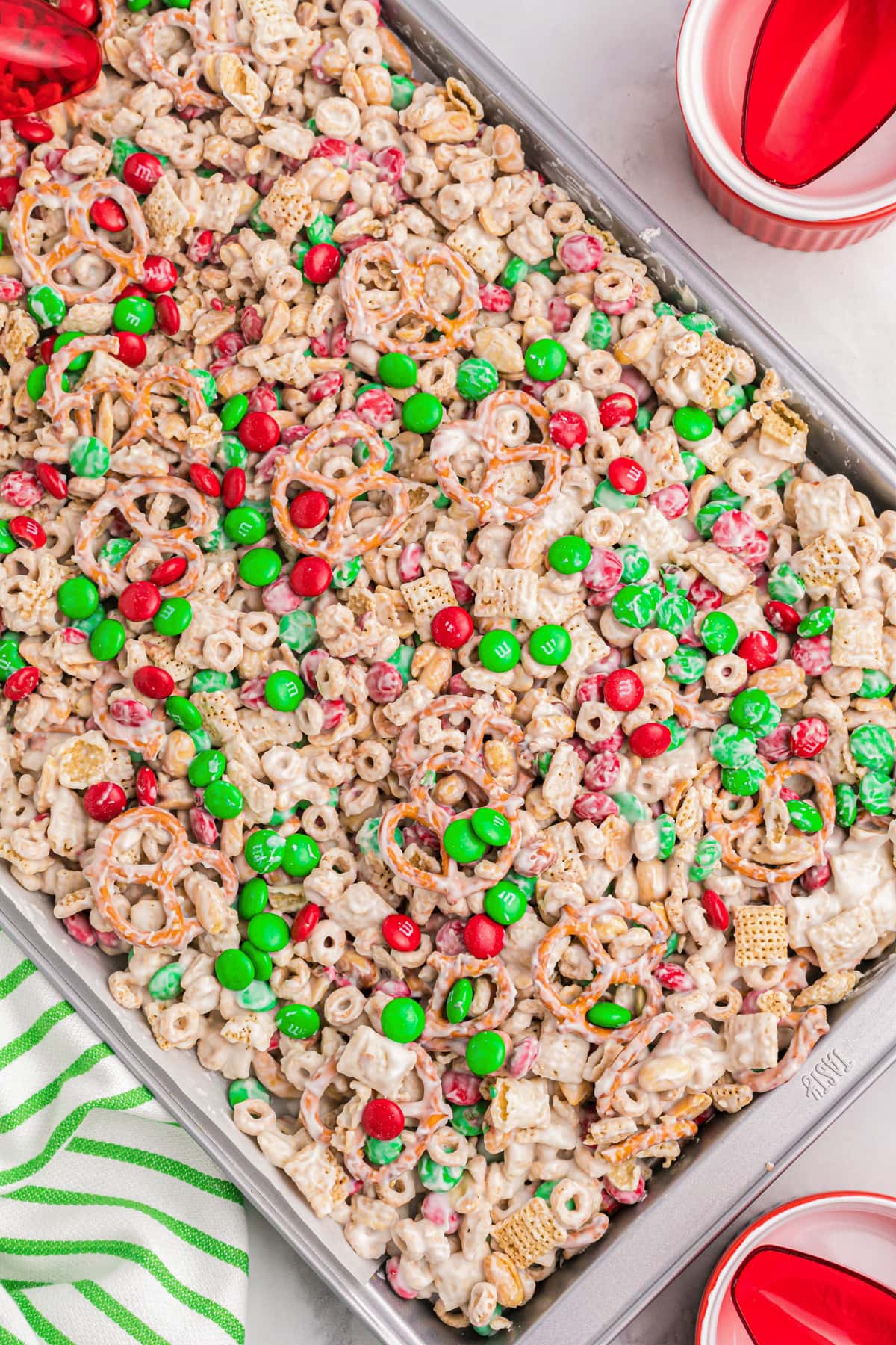 Close up of Christmas chex mix spread in a baking sheet to cool.