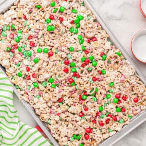 Christmas chex mix spread on a baking dish.