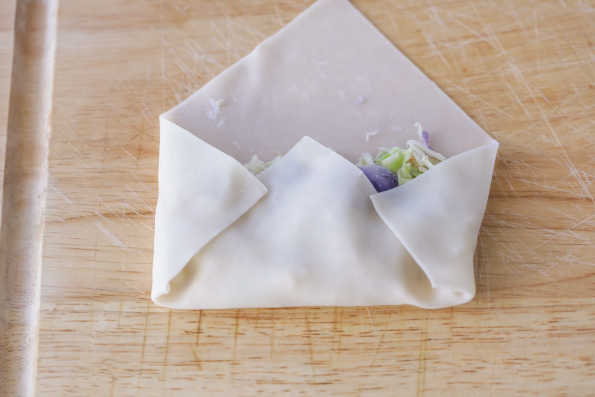 Egg roll filling in and starting to be rolled up.
