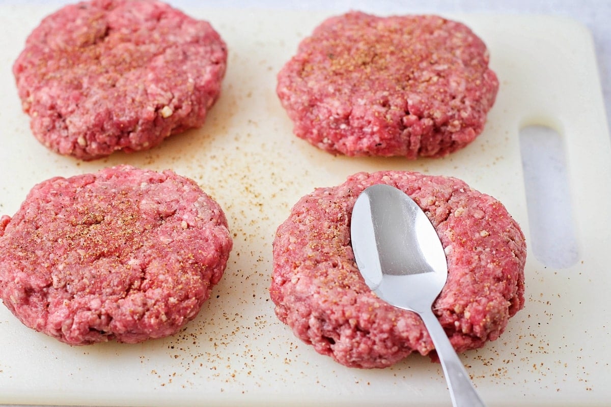 Pressing spoons into a patty for hamburger recipe.