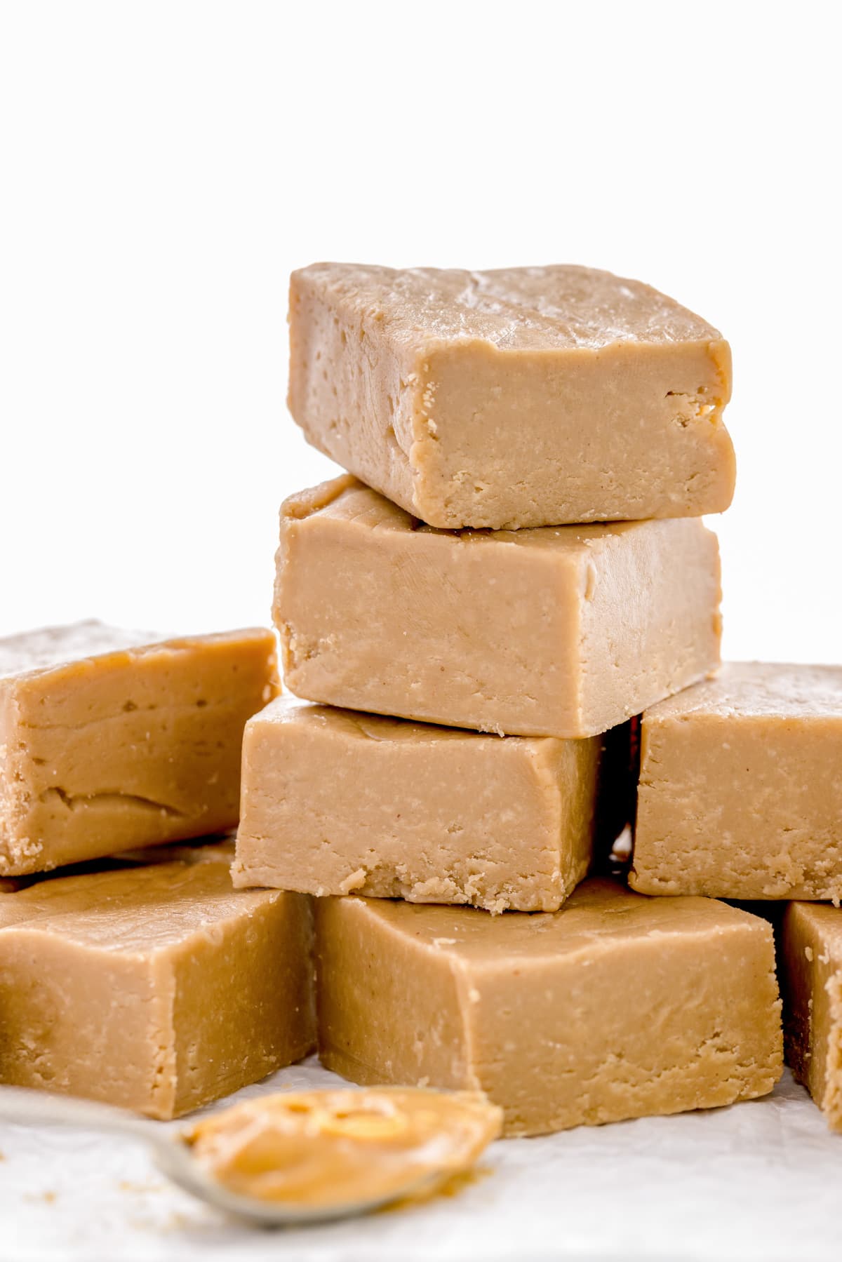 Cut squares of peanut butter fudge stacked on wax paper.