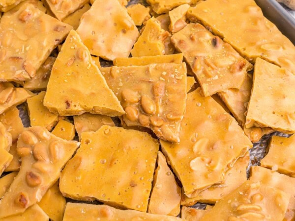 Peanut Brittle broken into pieces on baking sheet.