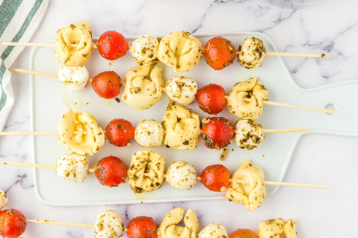 Tortellini skewers served on a white platter.