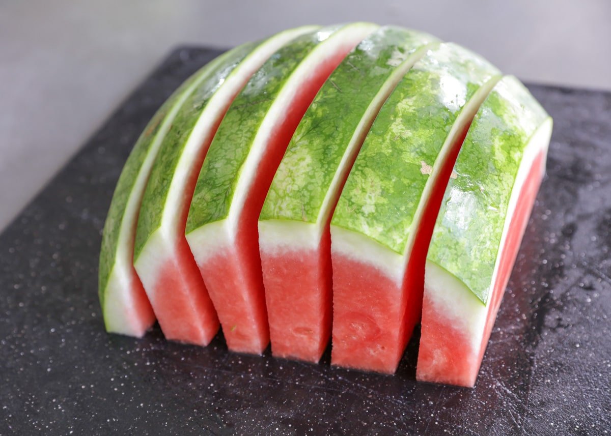 Process picture of how to cut a watermelon into sticks.