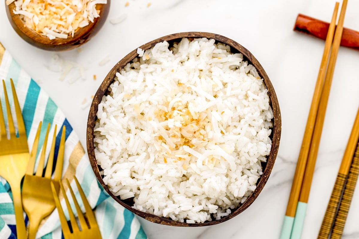 A bowl of coconut rice topped with toasted coconut.