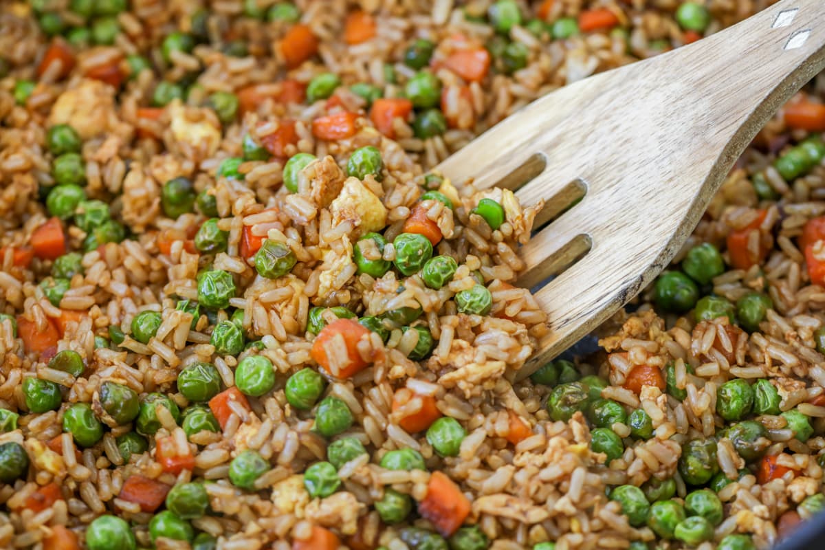 Close up of a spoon scooping homemade fried rice.