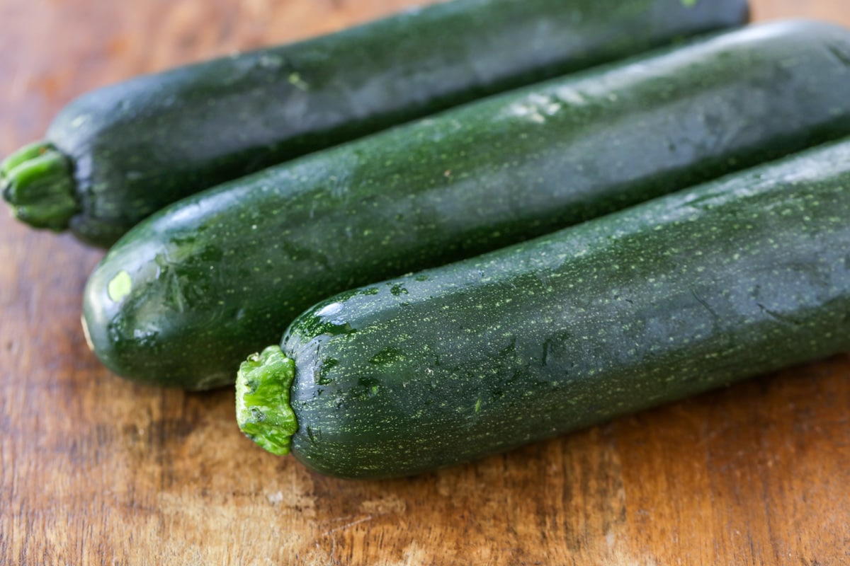 3 zucchini on a cutting board.