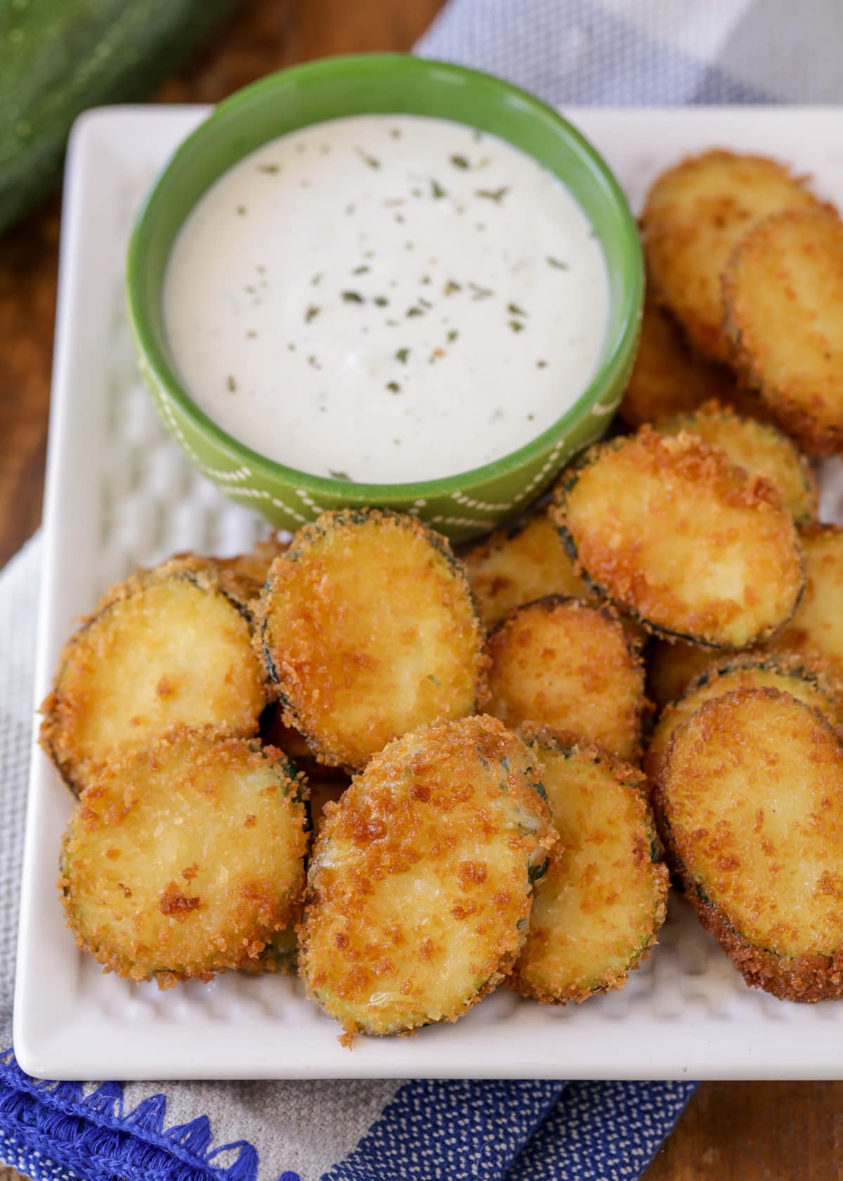 A plate of golden fried zucchini served with ranch dressing.