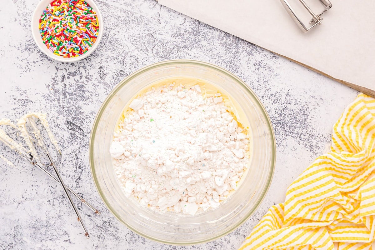 Mixing funfetti cake mix cookies batter in a glass bowl.