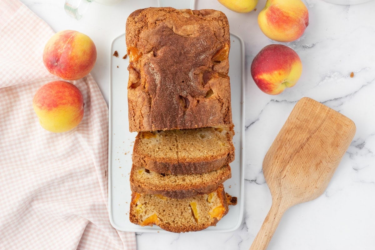 Peach bread recipe sliced on white plate.