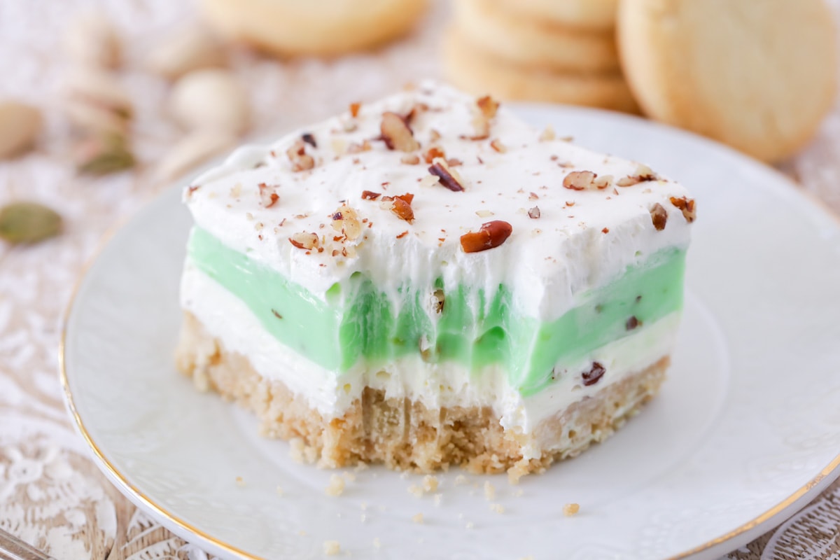 Layered pistachio dessert with a bite missing.