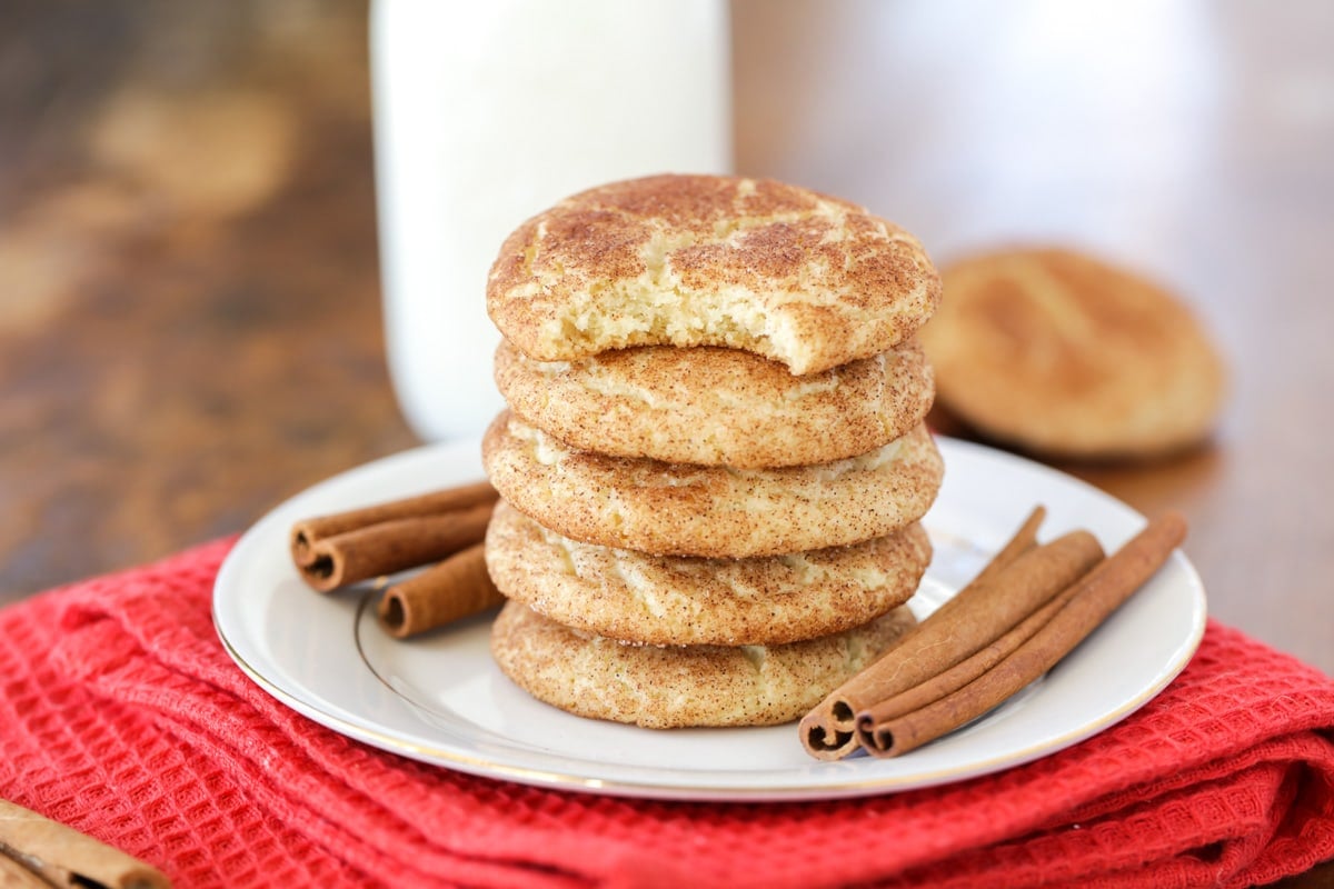 Snickerdoodle cookies stacked on a white plate.