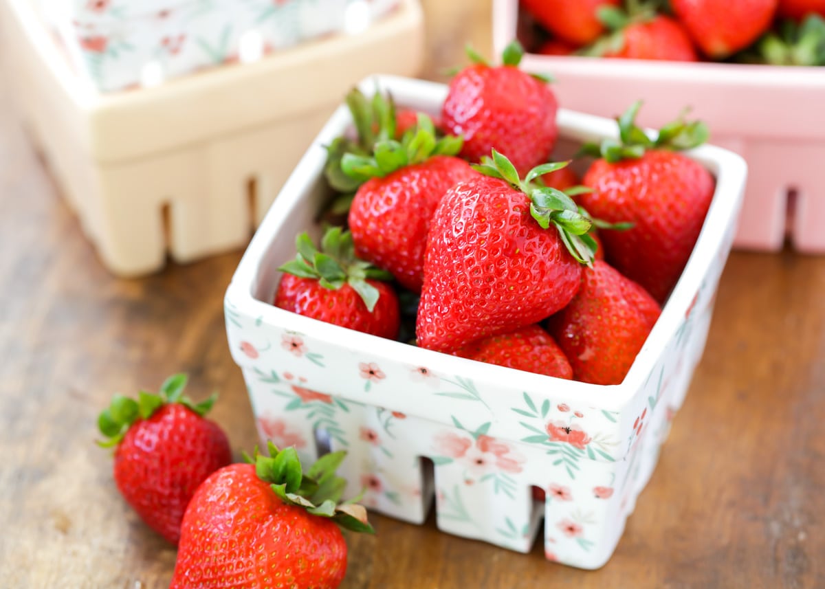 Container of strawberries on a table.