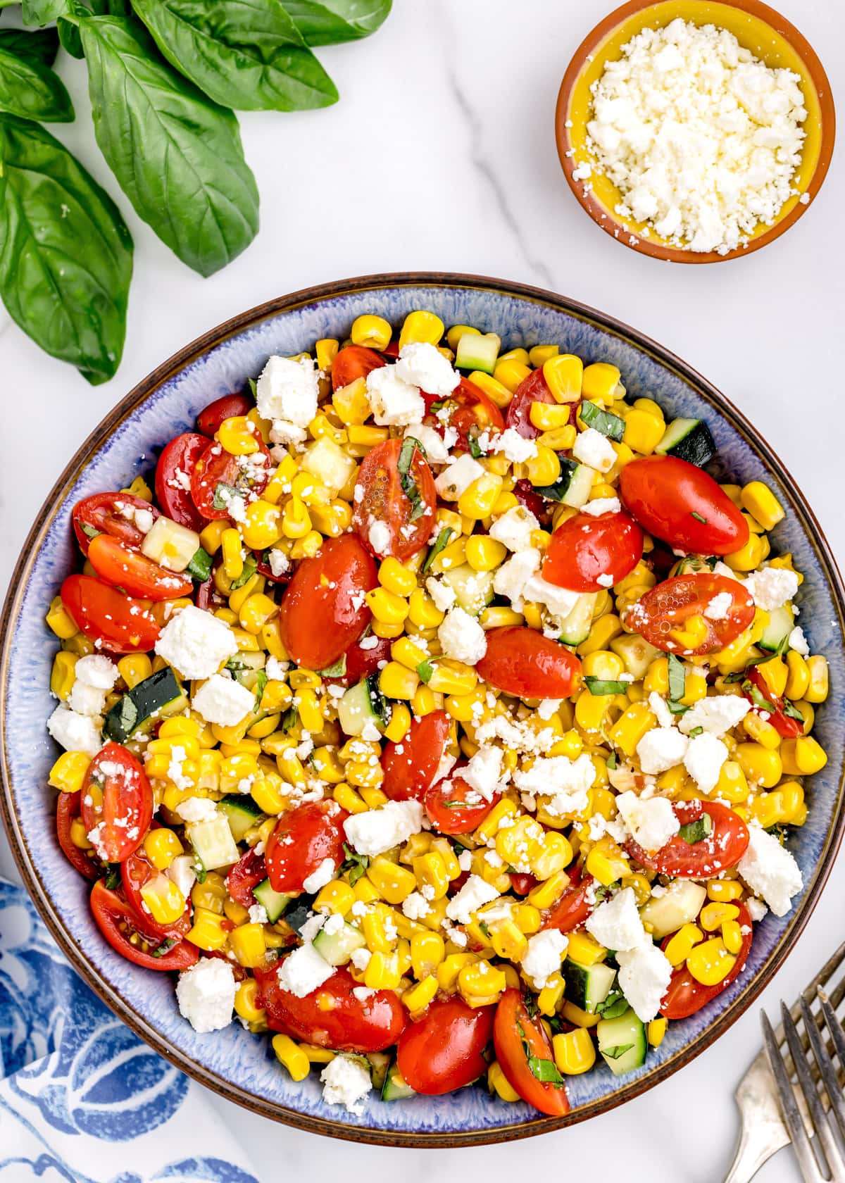 Summer corn salad topped with grape tomatoes, feta, and Italian dressing.