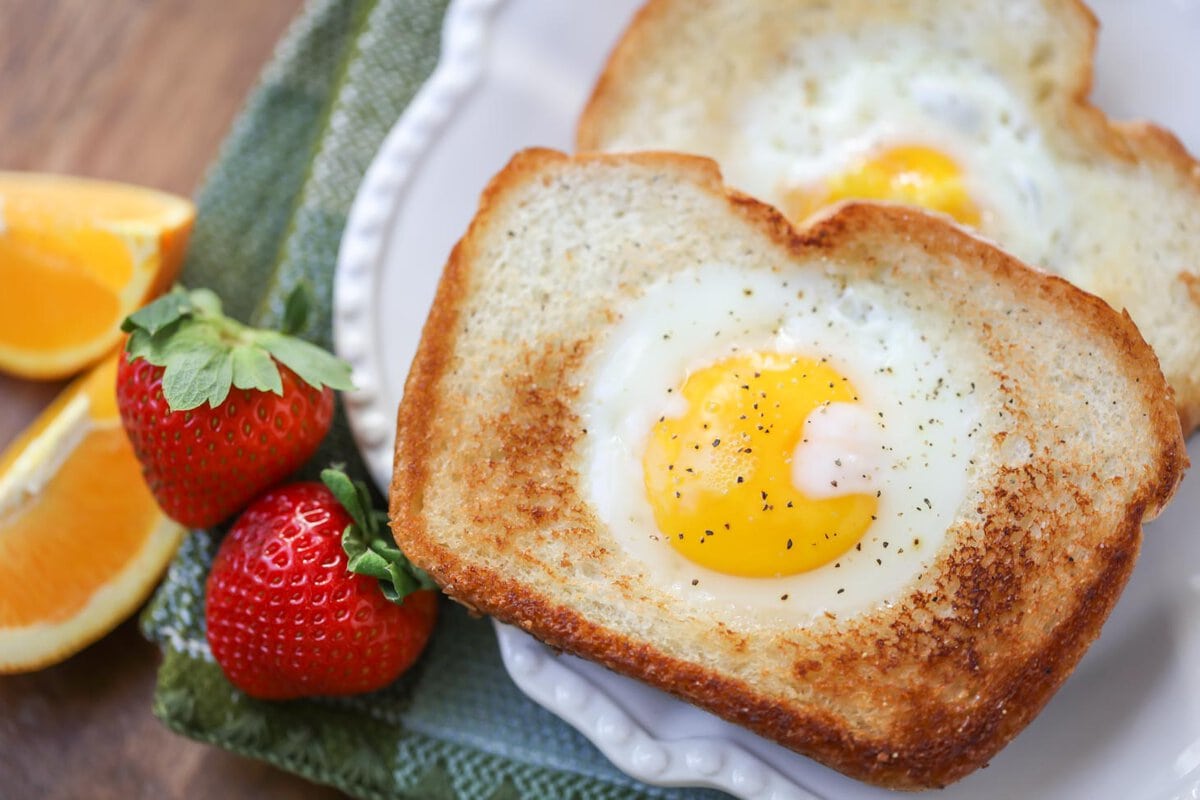 Two slice of toad in the hole on a white plate.