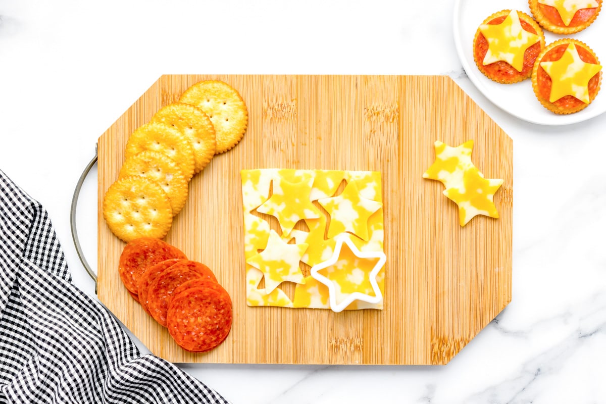Cutting star cheese for crackers on the after school snack board.