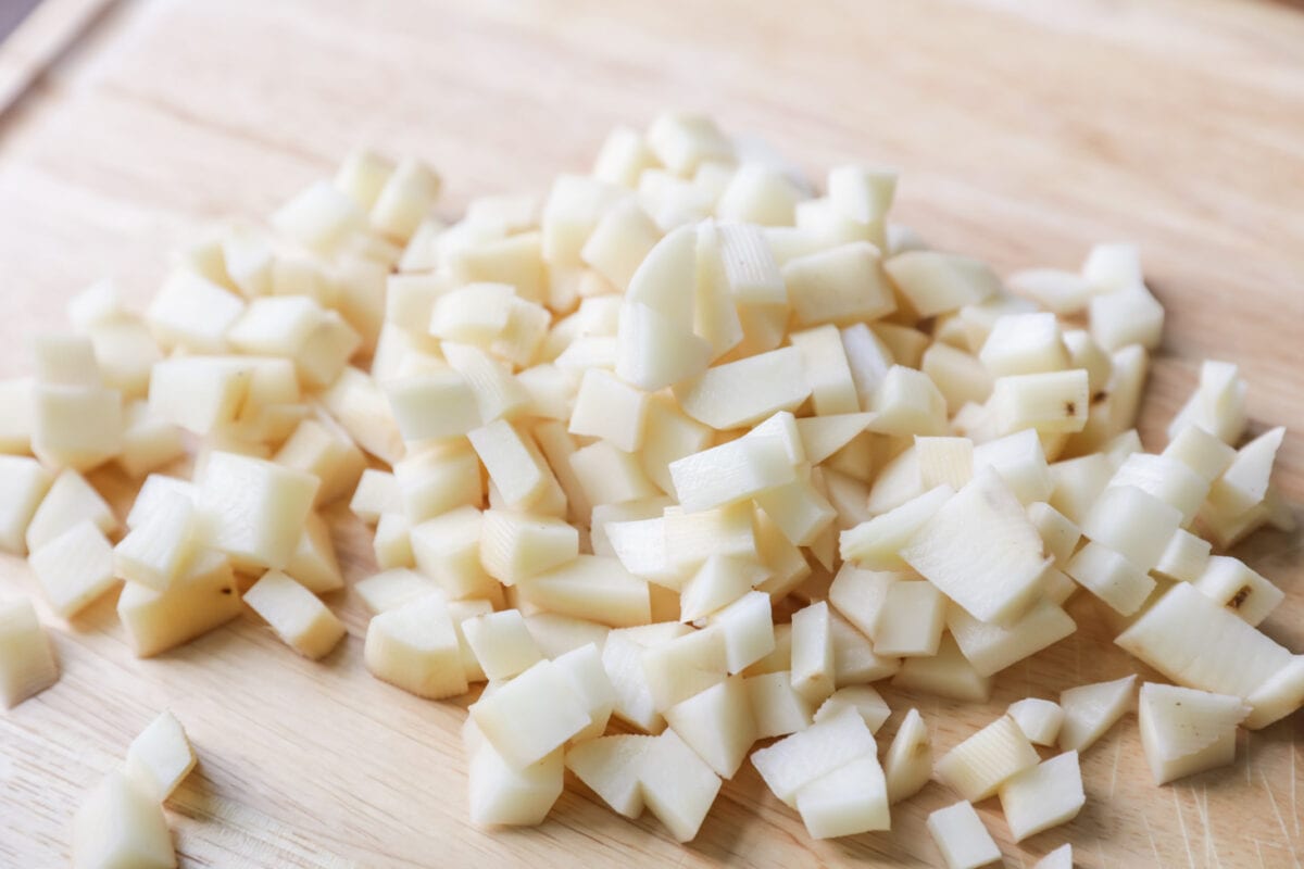 Cubed and peeled potatoes on cutting board for chicken pot pie recipe.