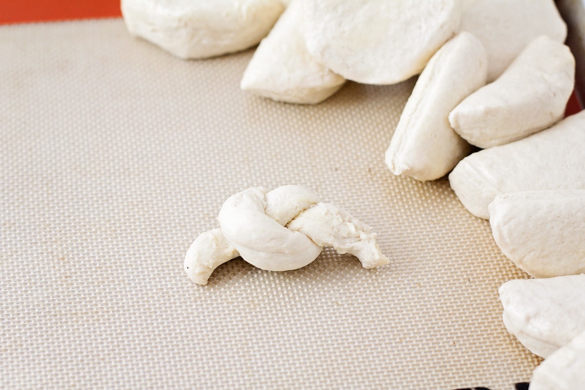 Tying garlic knot dough for making garlic knots.