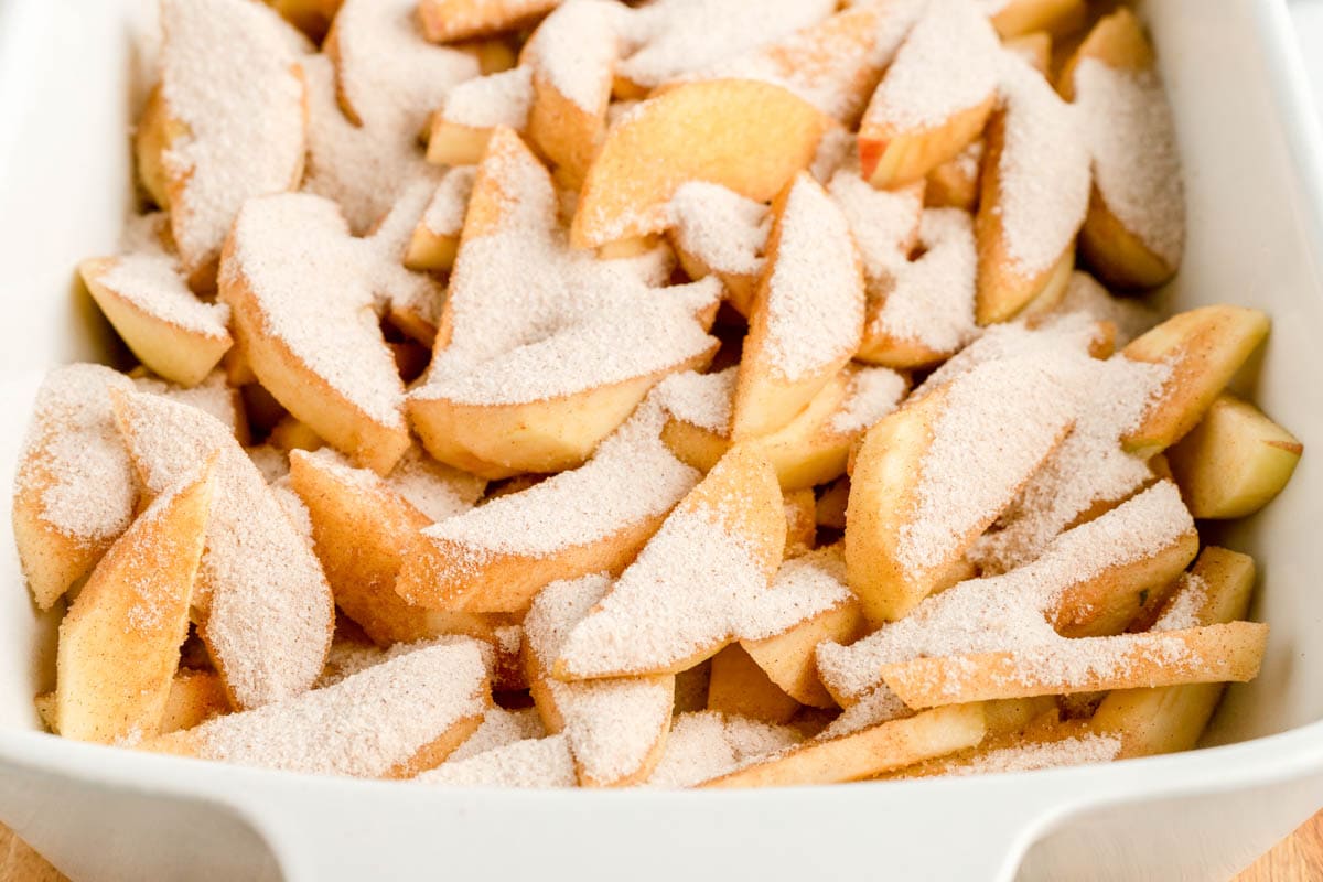 Cinnamon and sugar poured over sliced apples.